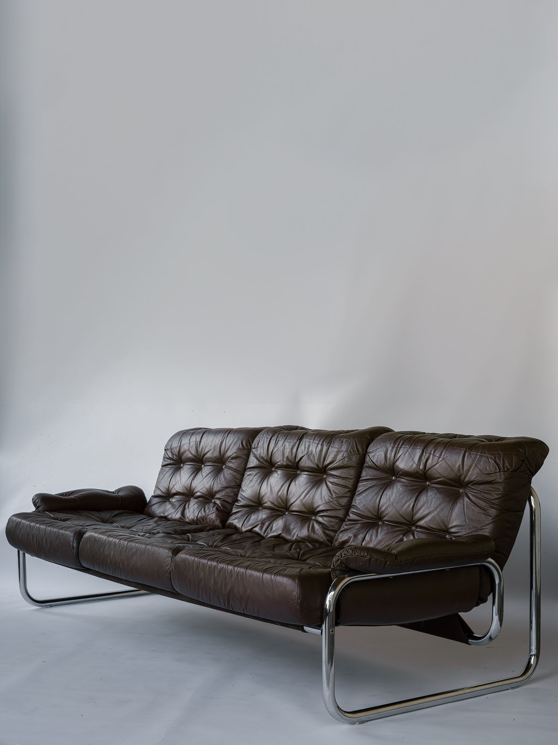 Soffa Borkum IKEA John Bertil Häggström 70-tal.  3-sits soffa i brunt skinn och kromad stomme. Utkom första gången 1978 i IKEA katalogen. Dynor och bärväv i otroligt fint bruksskick. L.218 cm D.93 H.70 Sitthöjd ca 37 cm.